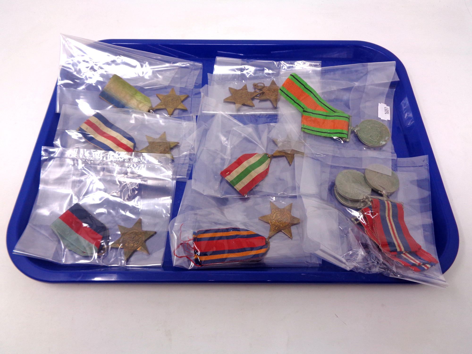 A tray containing eleven World War II medals, nine with ribbons to include 1939-45 Star,