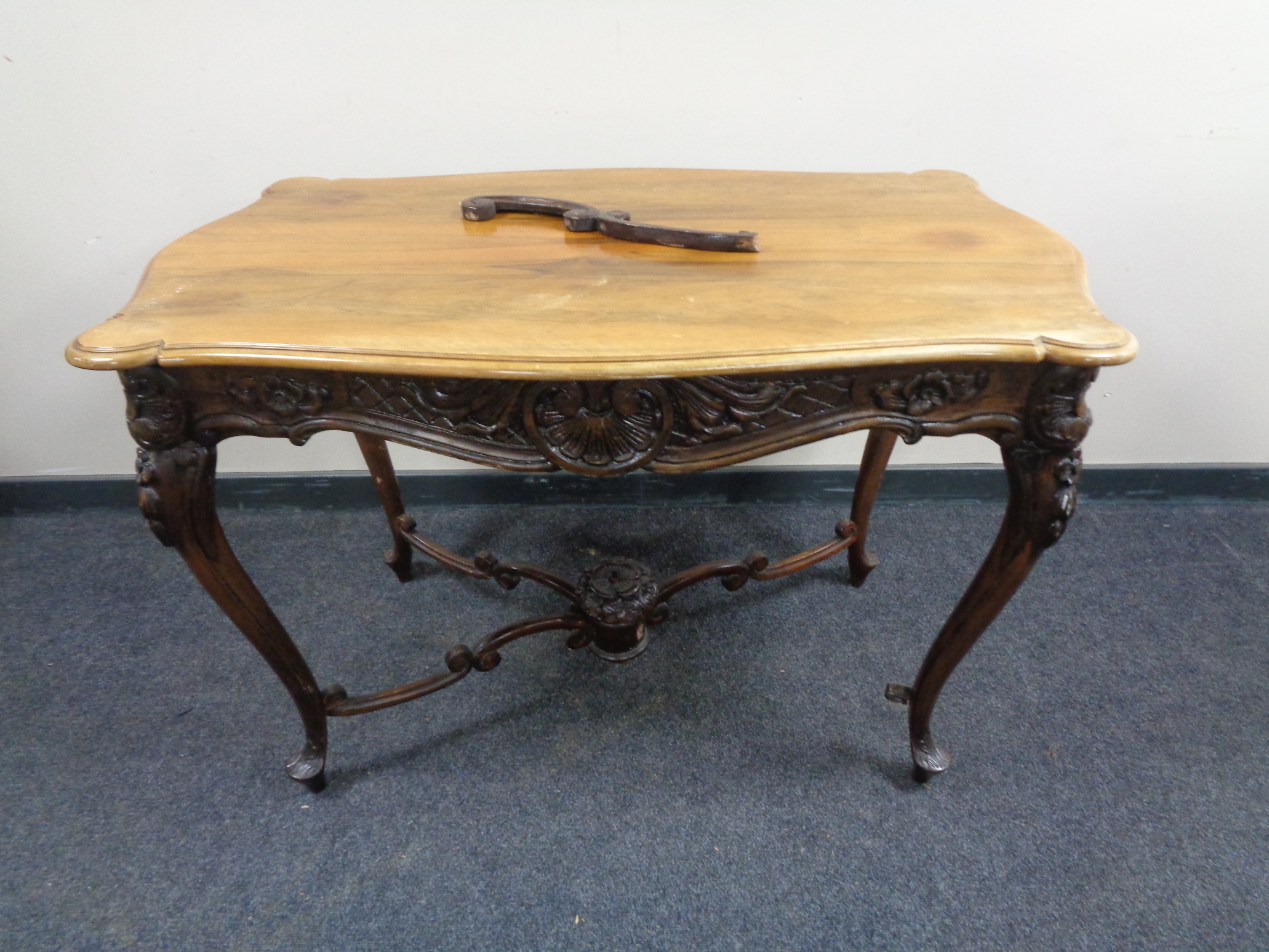 An early 20th century shaped walnut drawing room table on carved cabriole legs (under stretcher