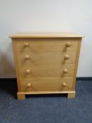 A four drawer chest with knob handles.
