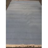 A contemporary fringed carpet on blue ground 405 x 278 cm