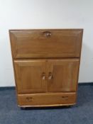 An Ercol elm cabinet fitted with cupboards and a drawer beneath