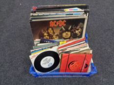 A crate containing vinyl LPs and 45 singles including ACDC, The Pogues, The Clash, The Jam,