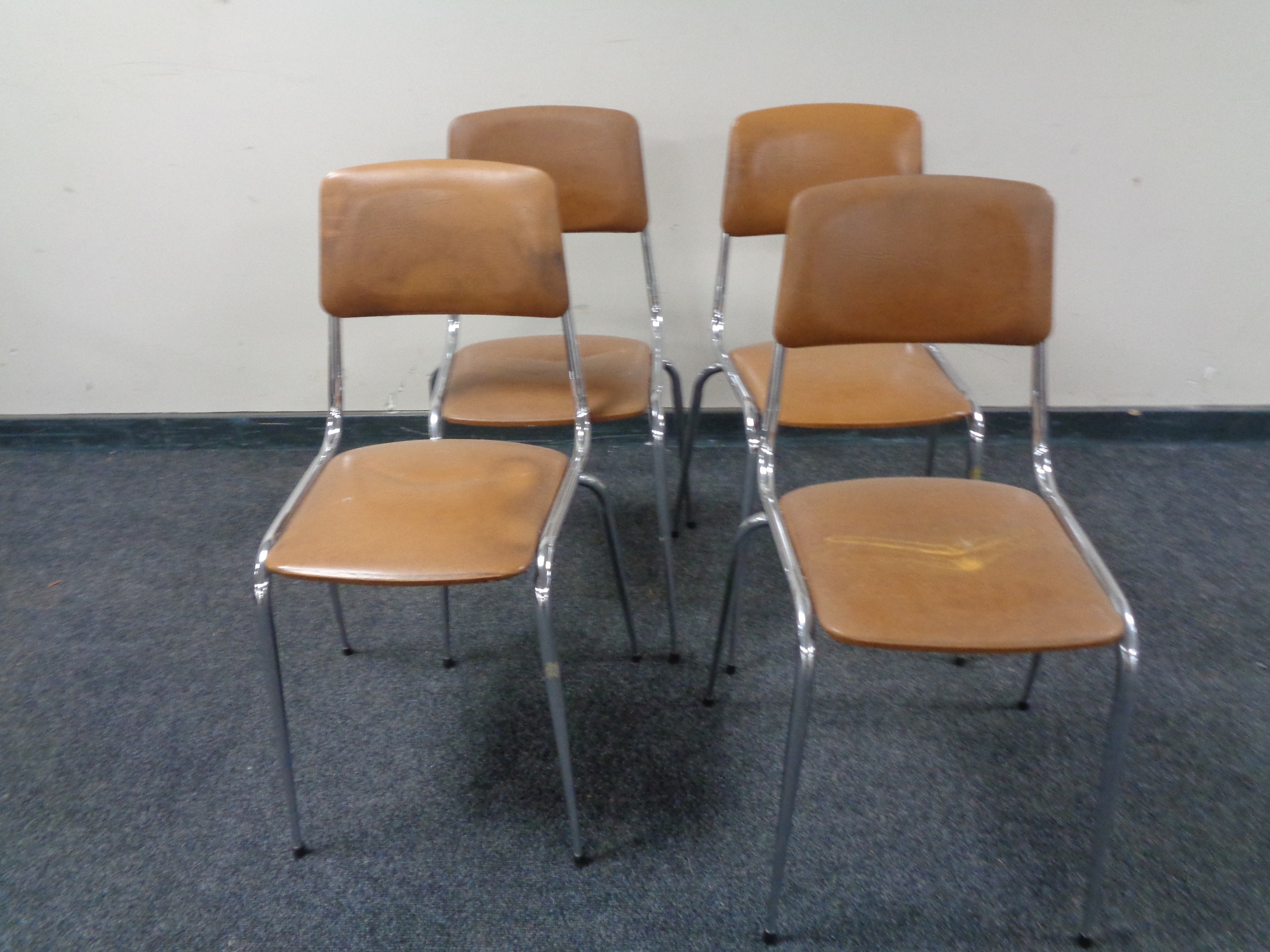 A set of four chrome and faux tan leather upholstered cafe chairs