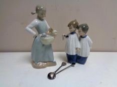 A Nao figure of a girl with kittens, a Nao figure of two choir boys,
