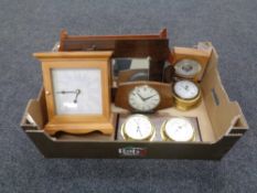 A box containing contemporary wall clocks and barometers.