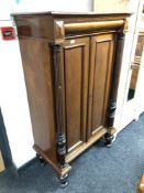 A continental mahogany double door cabinet with pillar supports