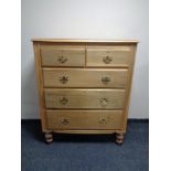 A pine chest of five drawers with brass bow handles