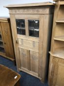 A continental glazed oak single door cabinet