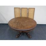 A heavily carved oak circular pedestal dining table