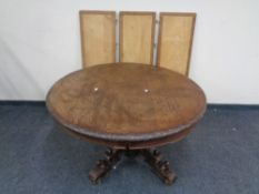 A heavily carved oak circular pedestal dining table