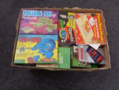 A box containing a large quantity of games including Tug of War, Follow On, Match 4, Dominoes,