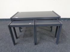 A nest of three 20th century painted teak tables