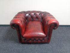 A Chesterfield style oxblood buttoned leather club armchair