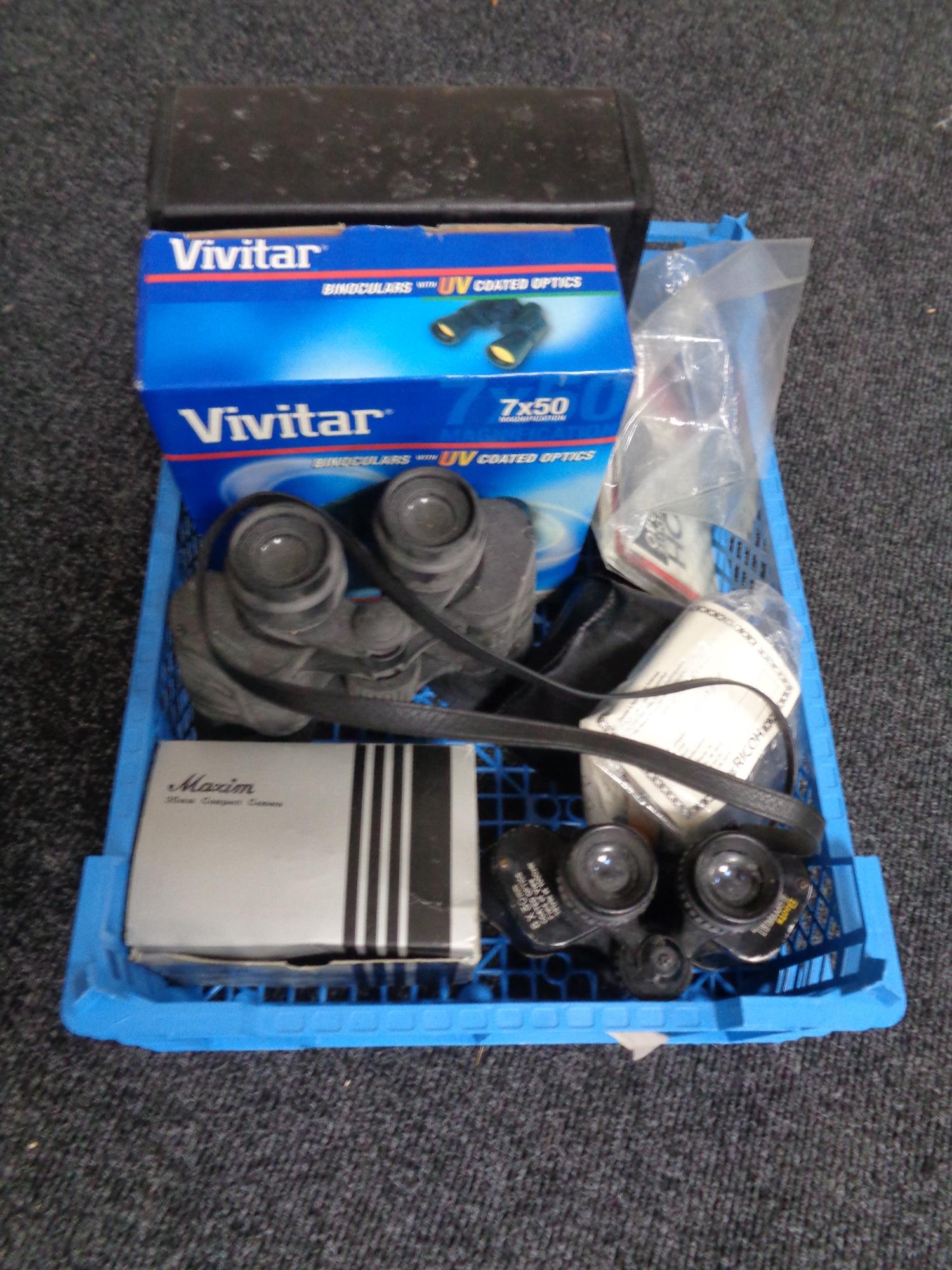 A crate containing Vivitar binoculars, boots, Admiral binoculars etc.