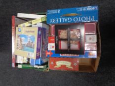 Two boxes containing contemporary jigsaws and puzzles, some sealed in retail packaging.