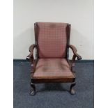 An Edwardian wing back armchair on pad feet