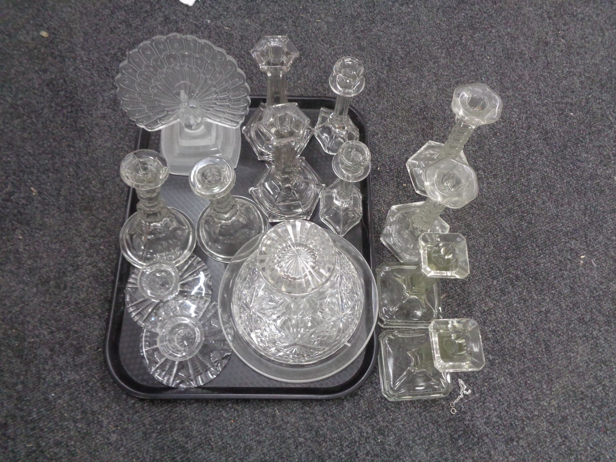 A tray of glassware comprising of cut glass ship's decanter, six pairs of candlesticks,