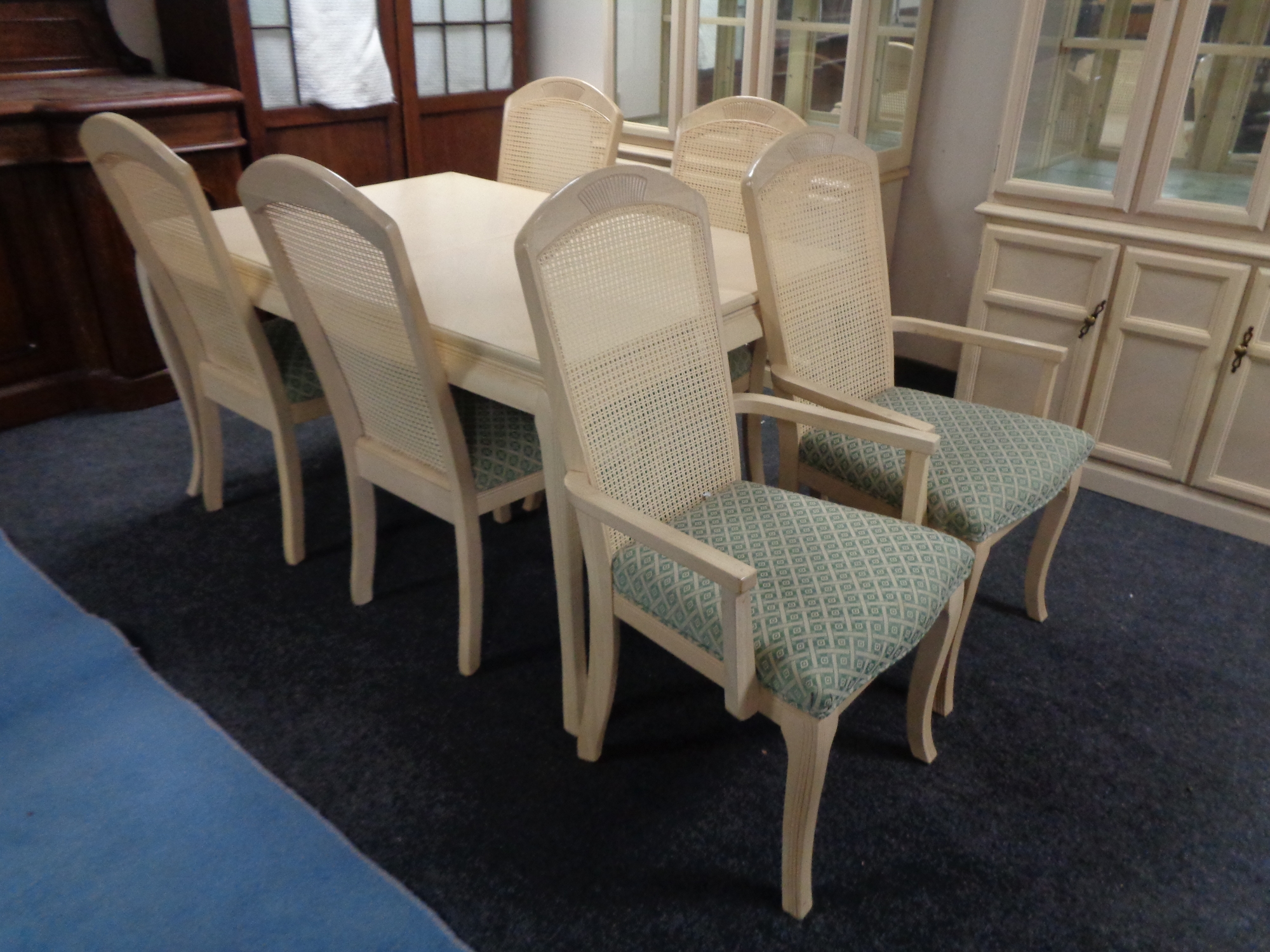 A contemporary extending dining table with leaf together with a set of six bergere backed dining