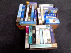 Three boxes containing a large quantity of puzzles and jigsaws.