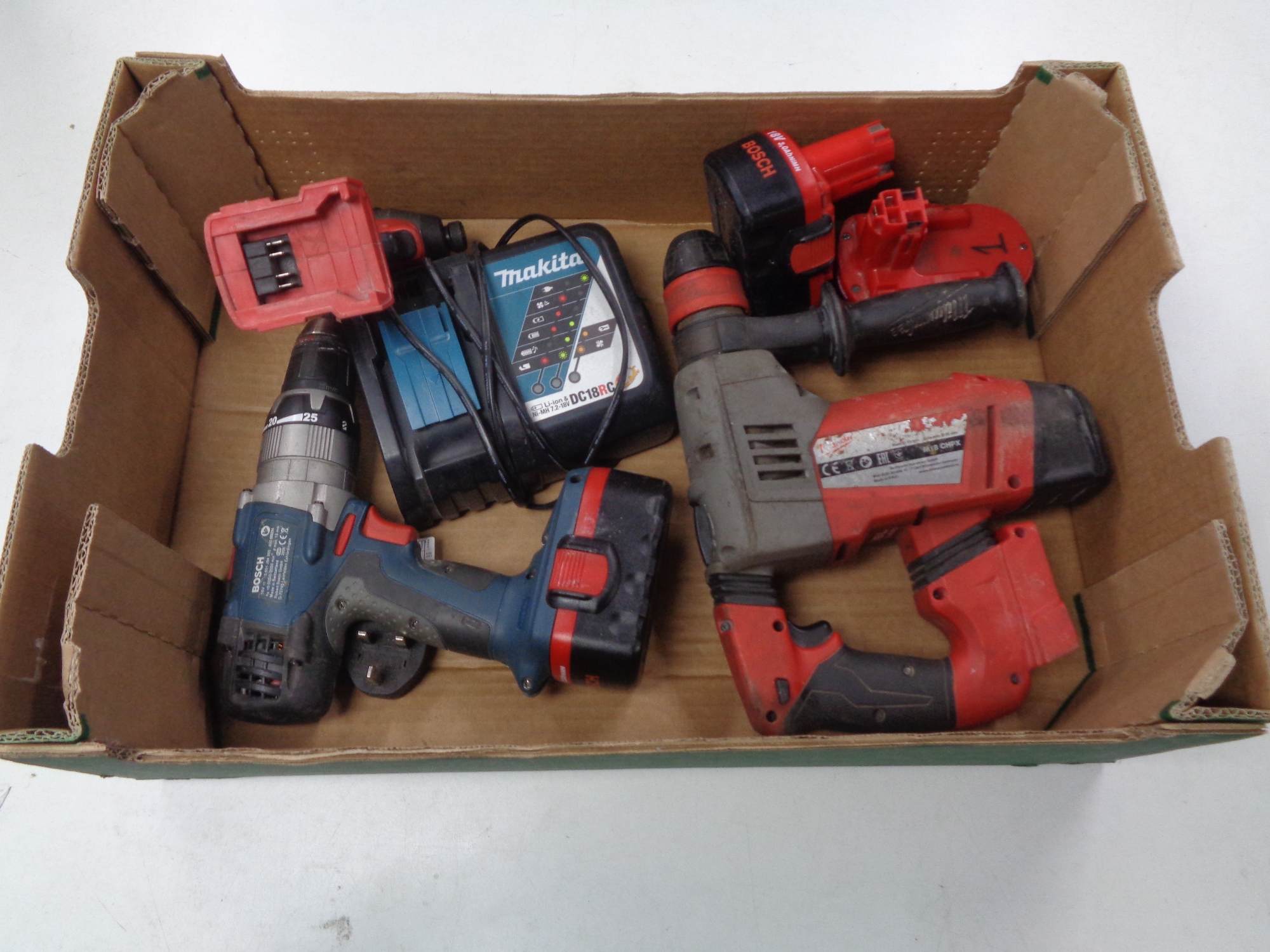 A box containing Bosch and Milwaukee electric hand drills, Makita battery charger.