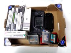 A box containing Sony PSP, Sega portable video game system, PSP games and Sega cartridges.