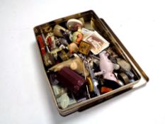 A tin containing collectable's including crucifix collector's cards, pens, wristwatch,