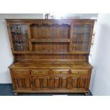 An oak kitchen dresser fitted four drawers and four cupboards beneath with leaded glass doors and