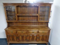 An oak kitchen dresser fitted four drawers and four cupboards beneath with leaded glass doors and