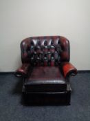 A Chesterfield oxblood buttoned leather wingback armchair