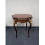 A late 19th century French ormolu mounted shaped top occasional table with red tooled leather top