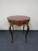 A late 19th century French ormolu mounted shaped top occasional table with red tooled leather top