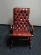 A beech framed rocking chair upholstered in oxblood buttoned leather upholstery