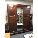 A late Victorian mahogany mirrored door triple wardrobe