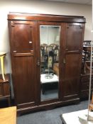 A late Victorian mahogany mirrored door triple wardrobe