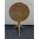 A circular pine pedestal occasional table