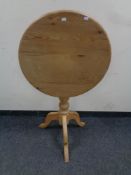 A circular pine pedestal occasional table