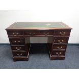 A reproduction mahogany serpentine front twin-pedestal desk,