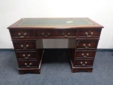 A reproduction mahogany serpentine front twin-pedestal desk,