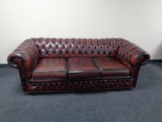 A Chesterfield oxblood buttoned leather three seater settee