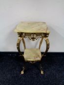 A gilt brass and onyx shaped two tier occasional table