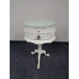 A cream and gilt oval occasional table on tripod pedestal support