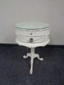 A cream and gilt oval occasional table on tripod pedestal support