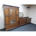 An Edwardian oak three piece bedroom suite comprising mirrored door wardrobe,