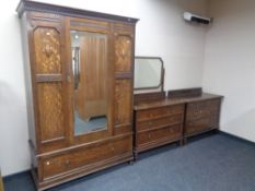 An Edwardian oak three piece bedroom suite comprising mirrored door wardrobe,