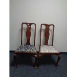 A pair of mahogany Queen Anne style dining chairs together with a circular fringed Indian rug.