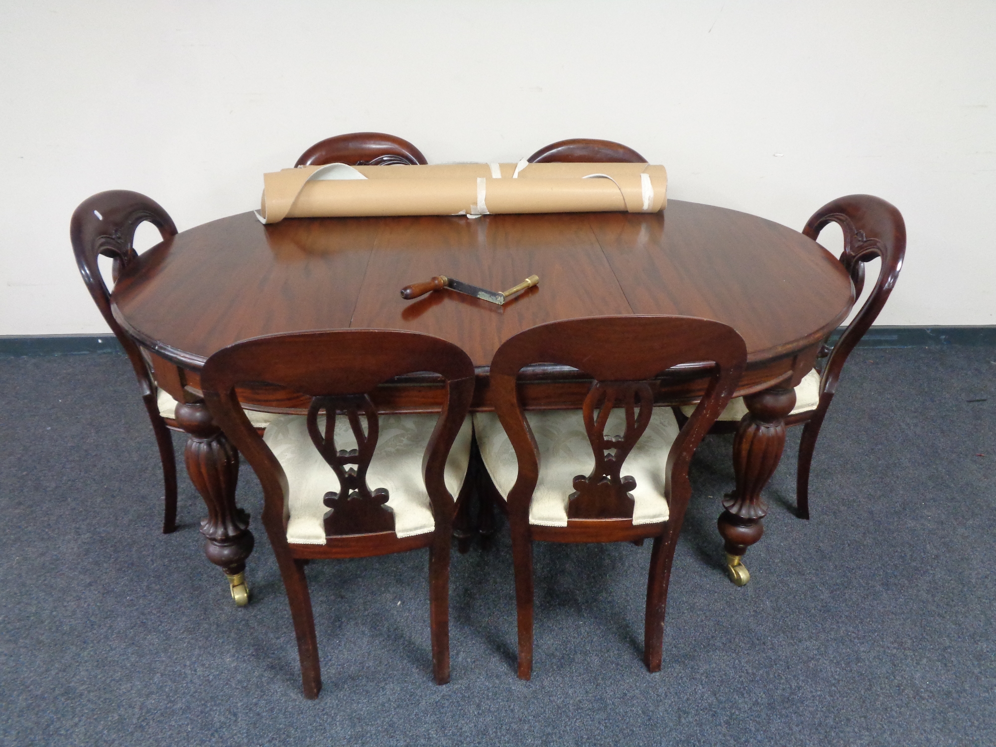 A reproduction mahogany extending dining table with leaf and winder together with a set of six