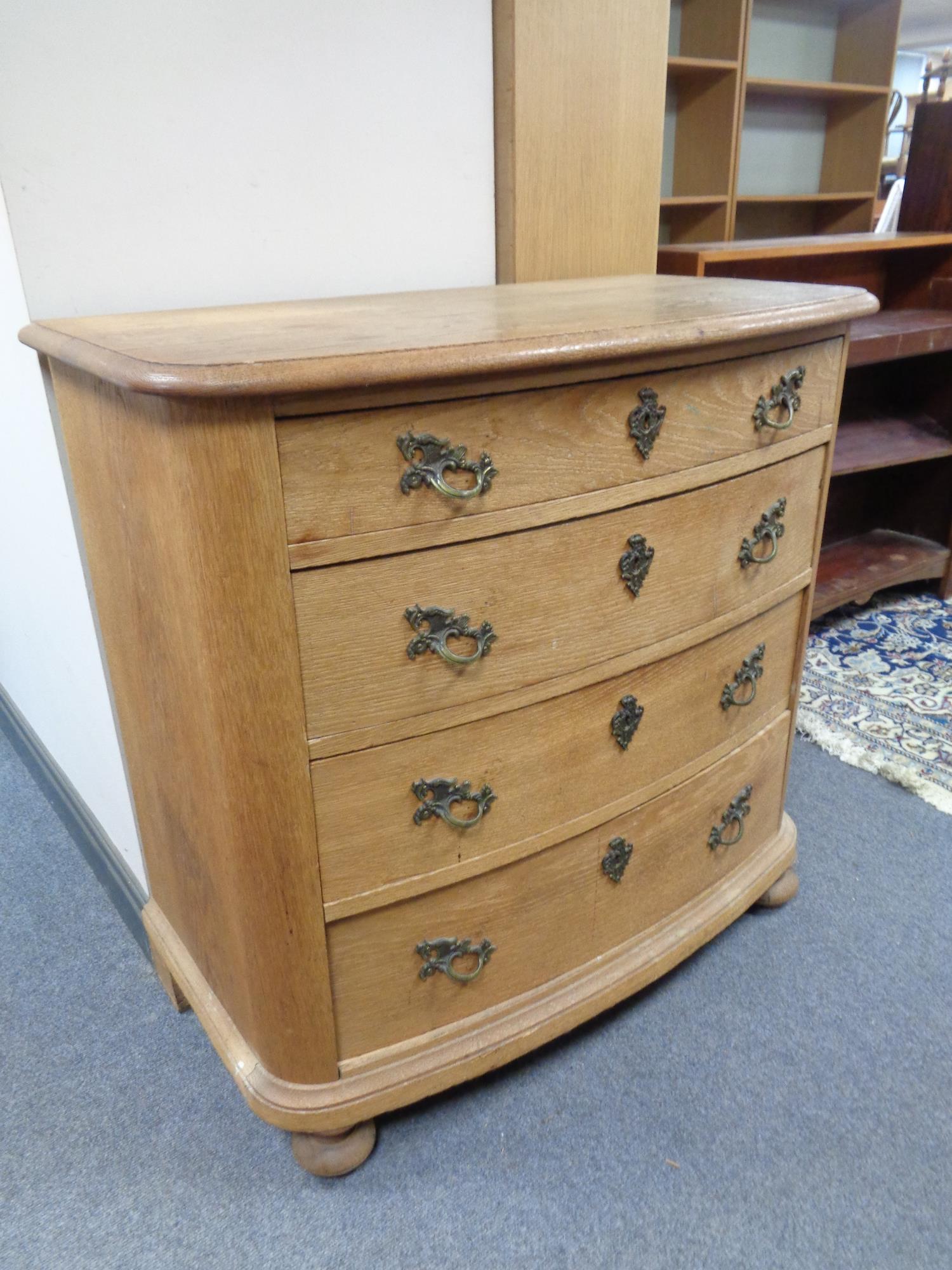 A late 19th century continental oak four drawer chest on bun feet