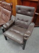 A 20th century armchair with brown buttoned leather cushions and arm rests