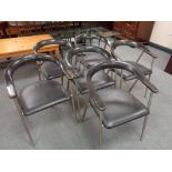 A set of six mid 20th century Danish elbow chairs with black vinyl upholstered seats on tubular