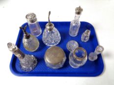 A tray containing a quantity of silver lidded and rimmed dressing table bottles,